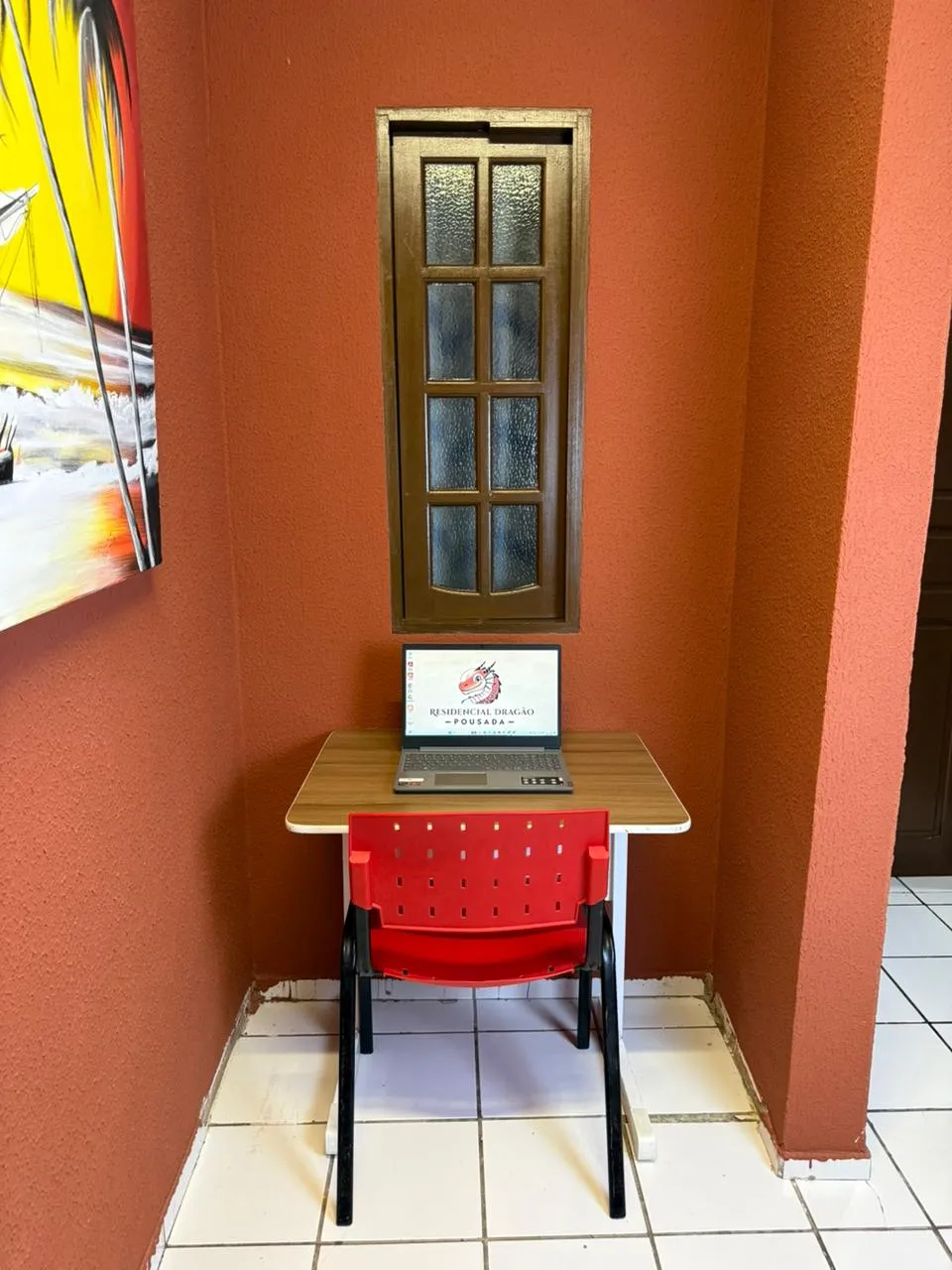 Mesa de estudo com notebook em área silenciosa da pousada